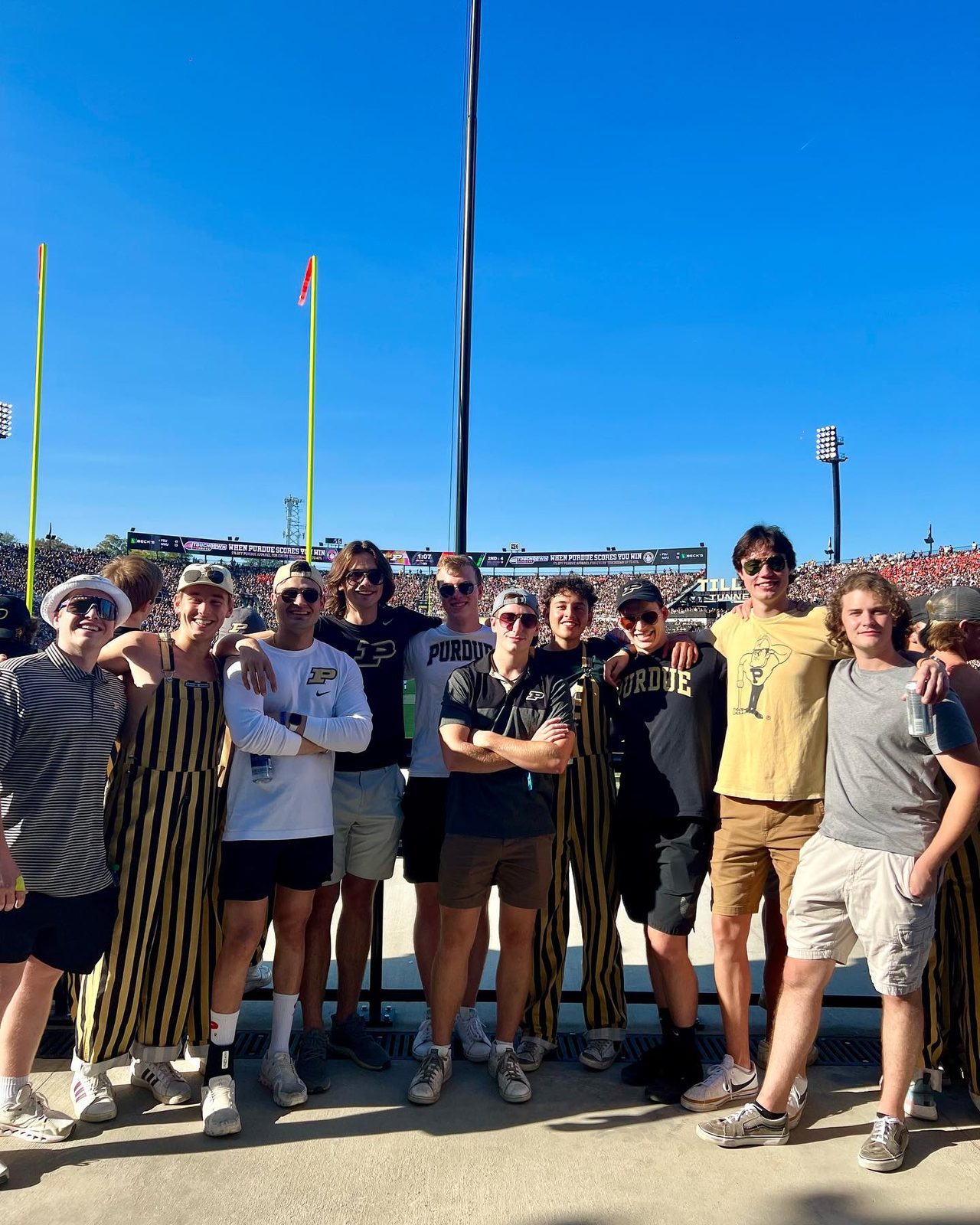 Brothers together at a Purdue football game under a clear sky