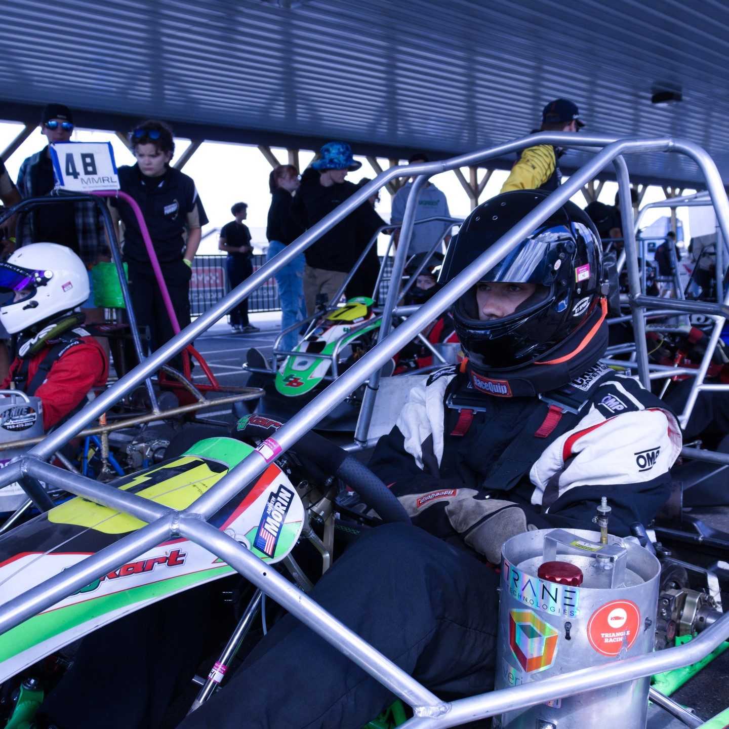 A Triangle driver suited up in the go-kart before a Grand Prix race