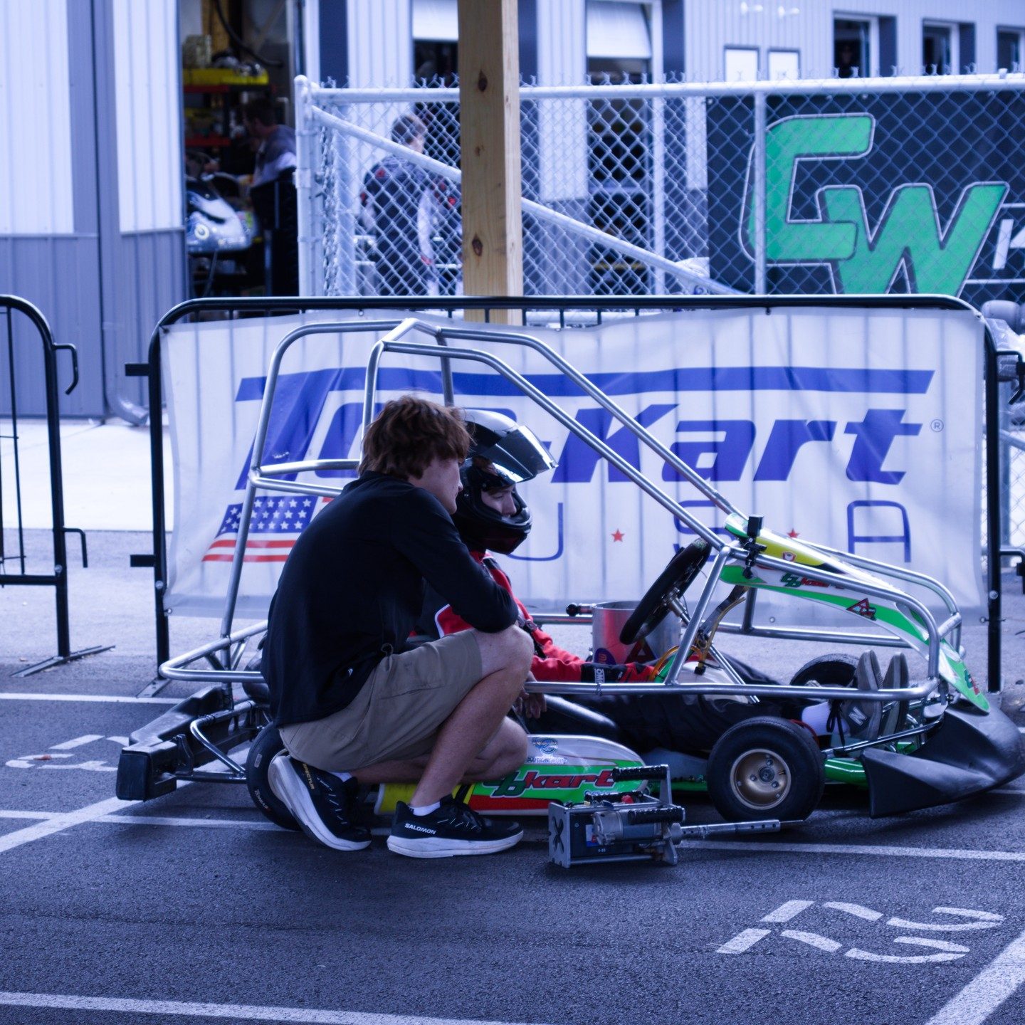 Brothers prepping the kart in the pits on race day