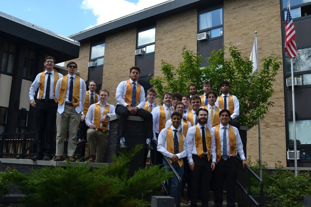 Brothers on the chapter house steps in graduation stoles